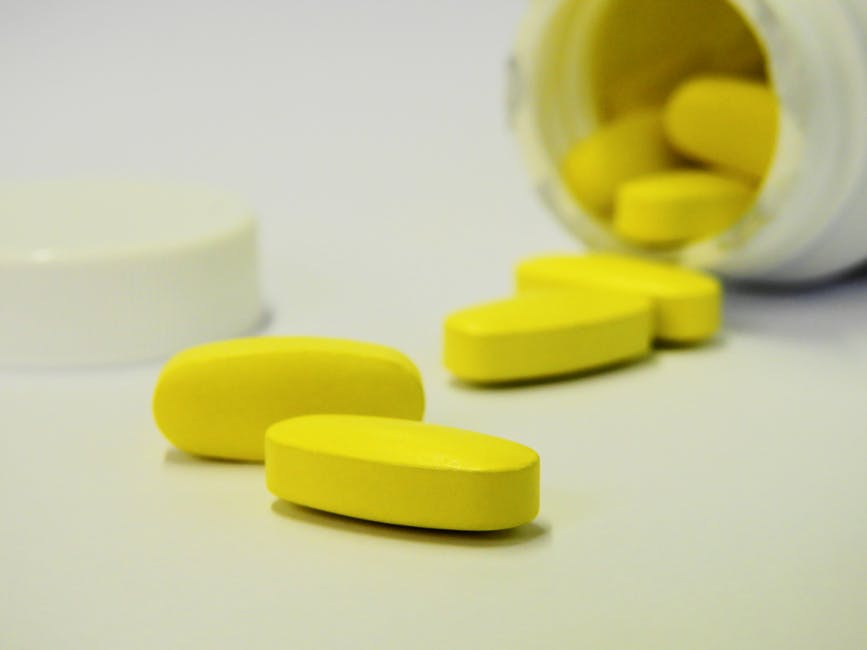 yellow pills spilling out of pill bottle